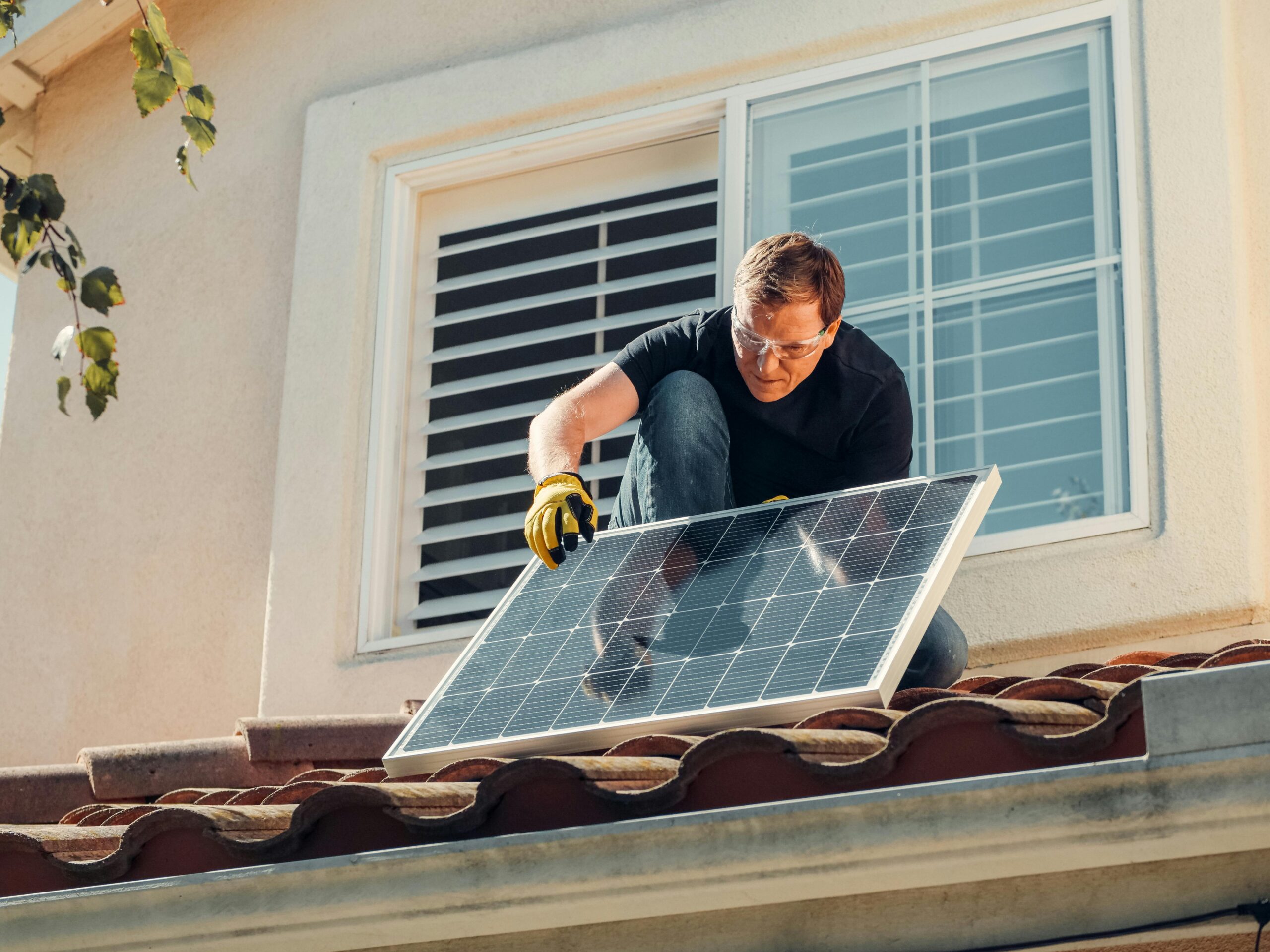 Mann installiert Photovoltaik auf einem Dach