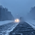 Auto auf Autobahn im Winter bei Schneefall und Nebel, schlechte Sicht