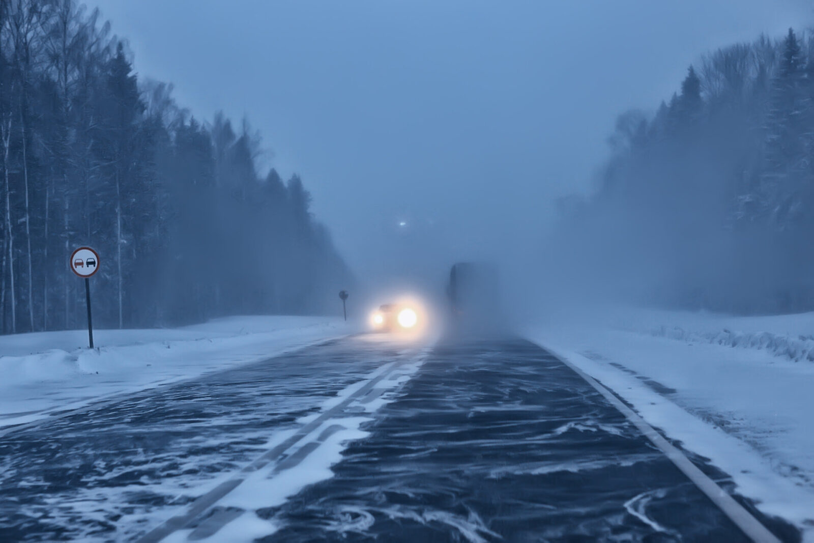 Auto auf Autobahn im Winter bei Schneefall und Nebel, schlechte Sicht